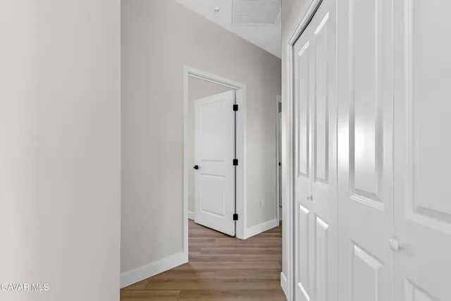 a view of a room with wooden floor and a ceiling fan
