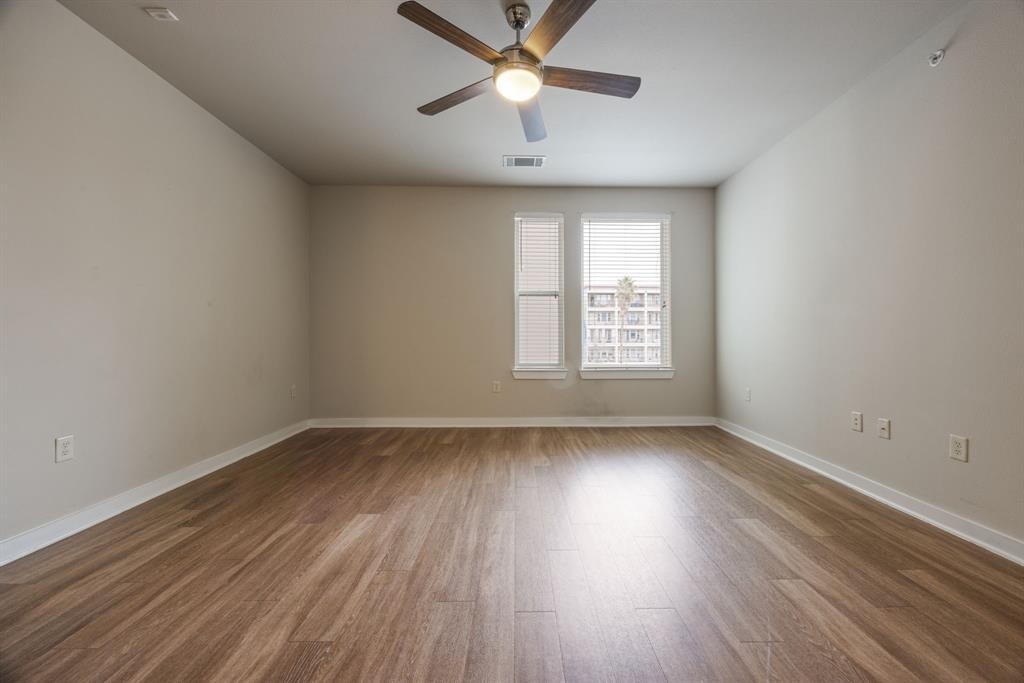 1900 Barton Springs Road, Unit 3013 Austin, TX 78704 - Photo 10 of 27 A well-lit room showcases rich hardwood flooring and a stylish ceiling fan.