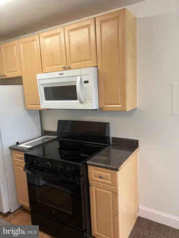 a kitchen with granite countertop a stove and a microwave