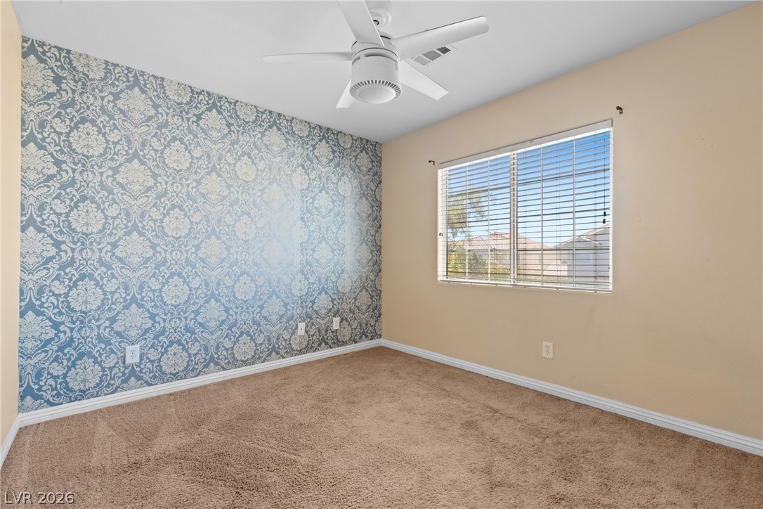 8934 Deep Ridge Court Las Vegas, NV 89178 - Photo 15 of 47 Comfortable carpeted bedroom with a charming patterned accent wall and ample natural light.