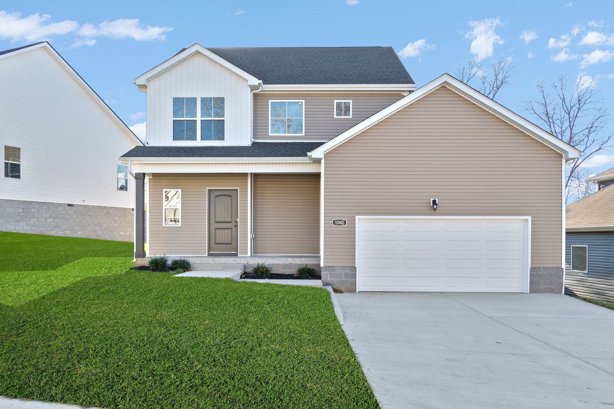 a front view of a house with a yard and garage