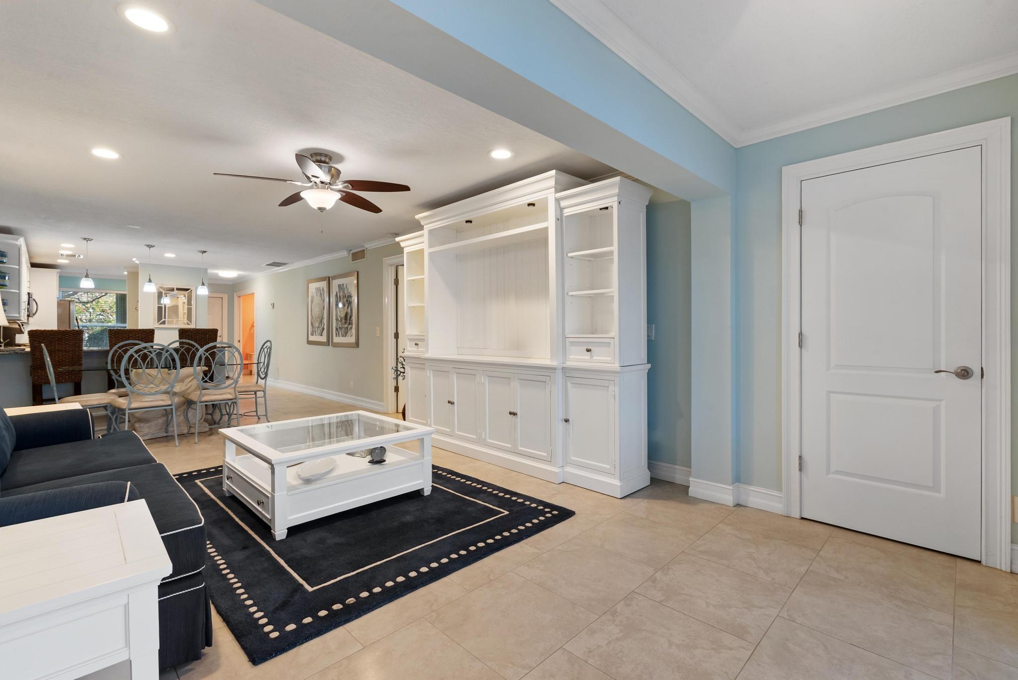 1280 Northwest 20th Avenue, Unit 101 Delray Beach, FL 33445 - Photo 12 of 31 a living room with furniture a mirror and a ceiling fan
