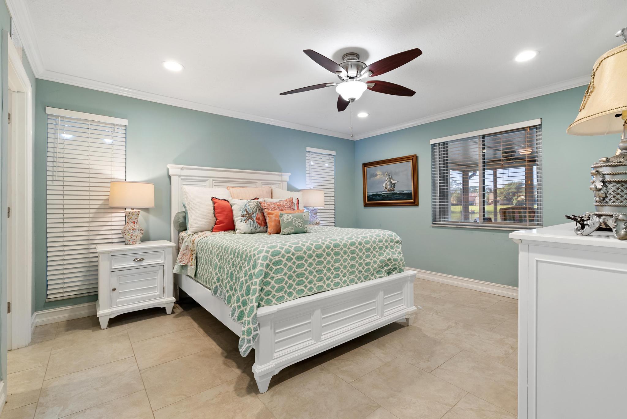 1280 Northwest 20th Avenue, Unit 101 Delray Beach, FL 33445 - Photo 18 of 31 a bedroom with a large bed and a chandelier