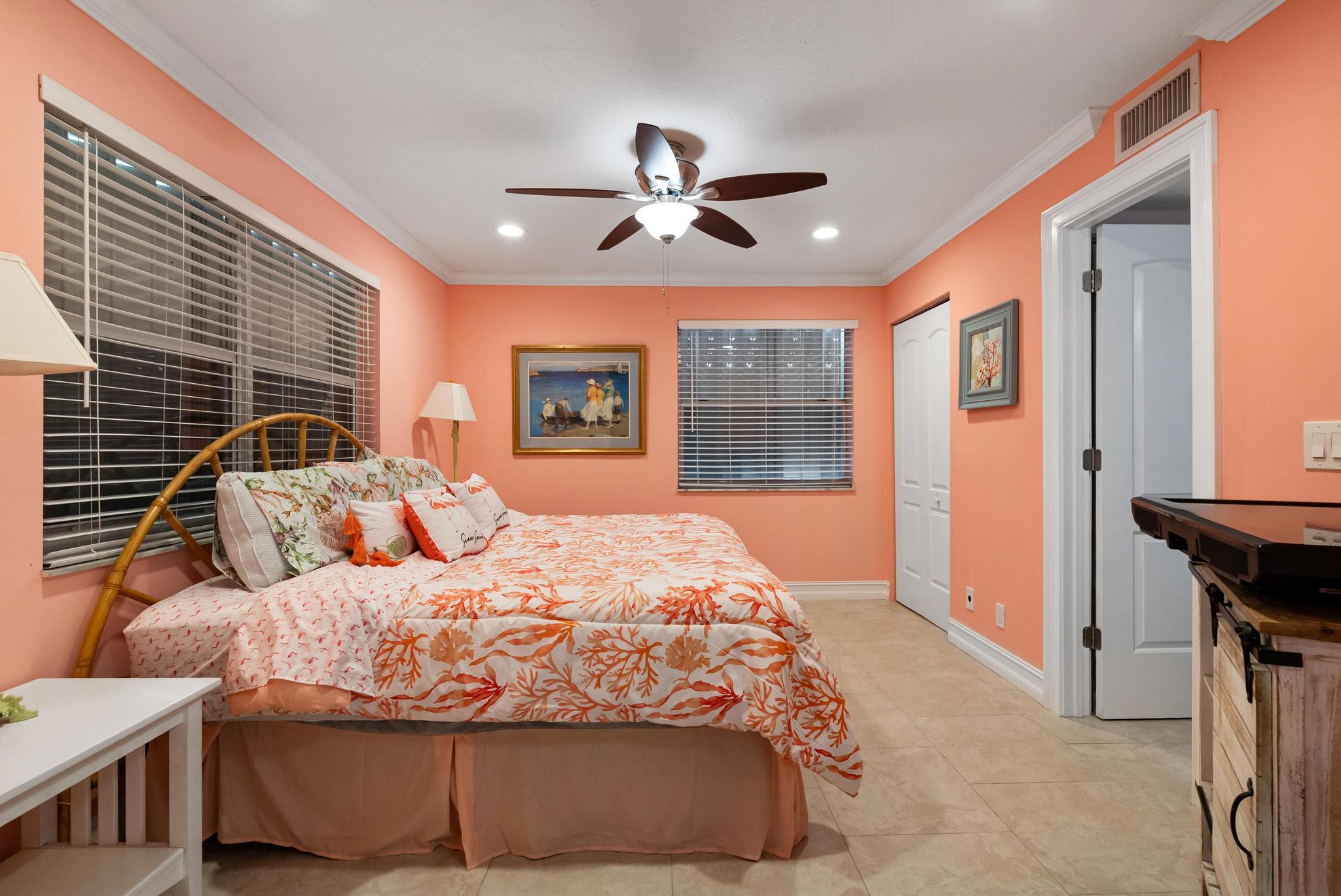 1280 Northwest 20th Avenue, Unit 101 Delray Beach, FL 33445 - Photo 22 of 31 a bedroom with a large bed and a chandelier