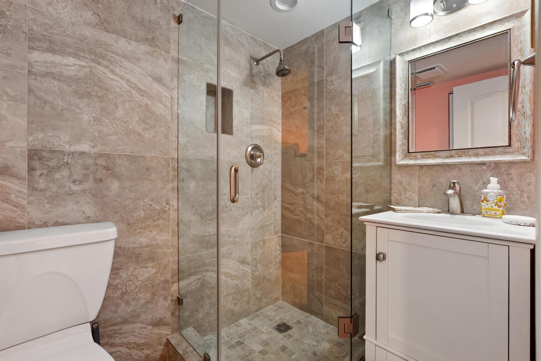 1280 Northwest 20th Avenue, Unit 101 Delray Beach, FL 33445 - Photo 23 of 31 a bathroom with a shower a toilet and sink