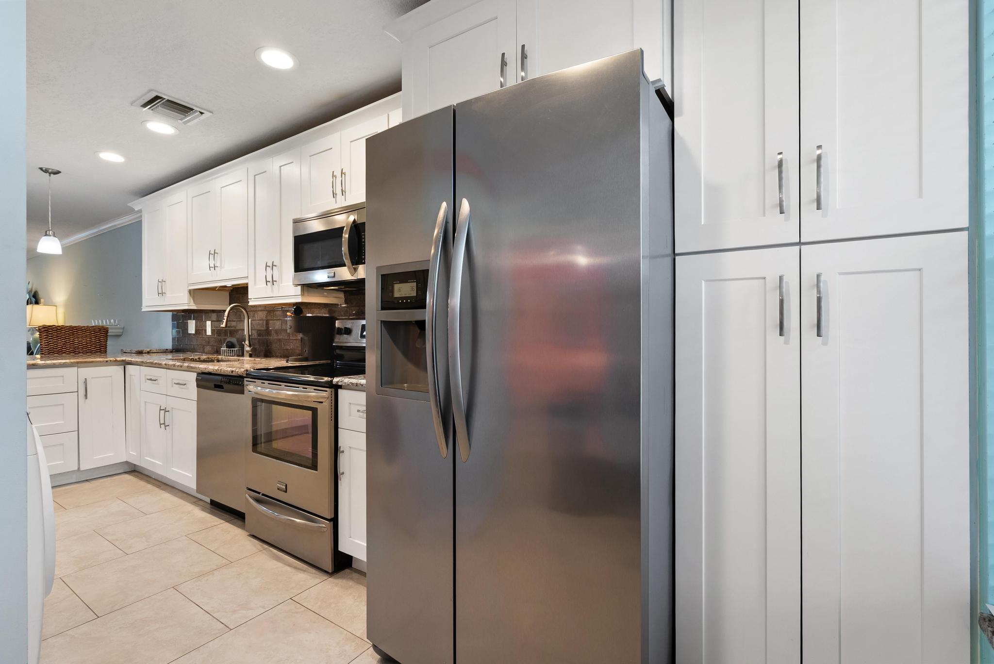 1280 Northwest 20th Avenue, Unit 101 Delray Beach, FL 33445 - Photo 9 of 31 a kitchen with cabinets and stainless steel appliances
