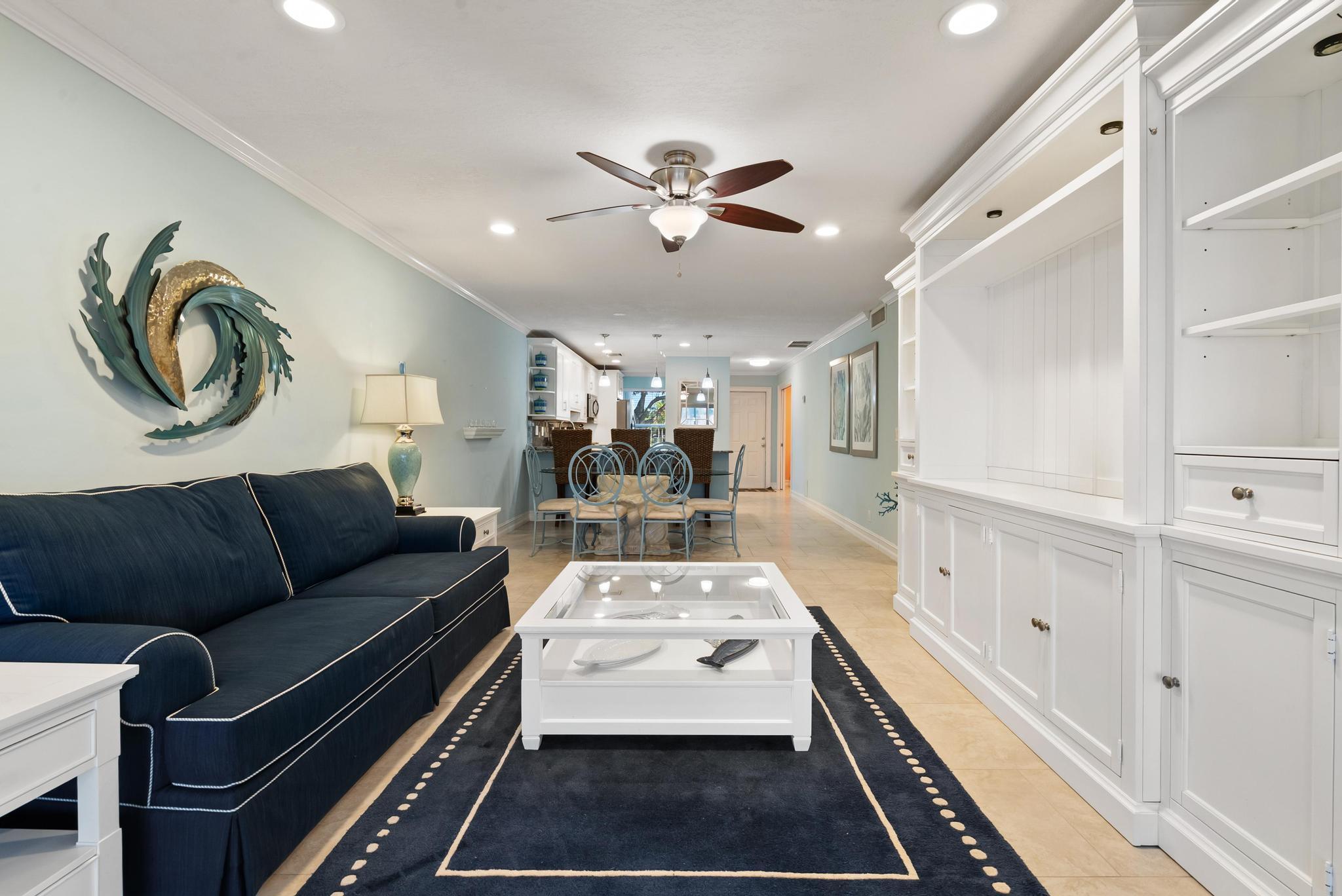 1280 Northwest 20th Avenue, Unit 101 Delray Beach, FL 33445 - Photo 10 of 31 a living room with furniture and a chandelier