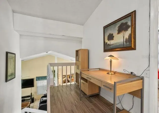 a view of a workspace with furniture and wooden floor