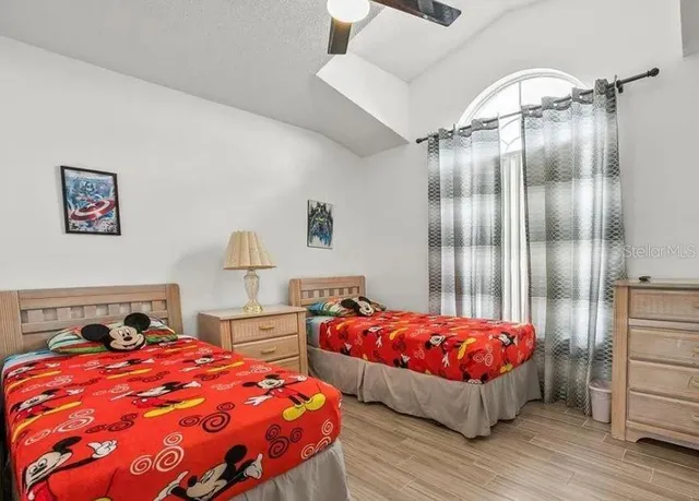 a bedroom with bed and wooden floor