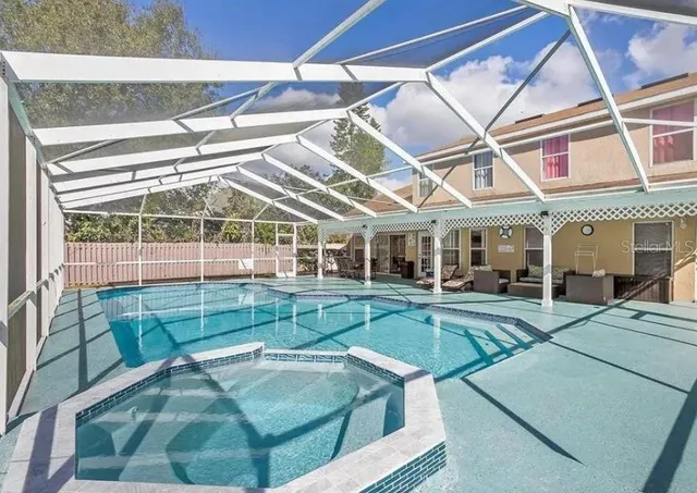 a view of a house with backyard and swimming pool