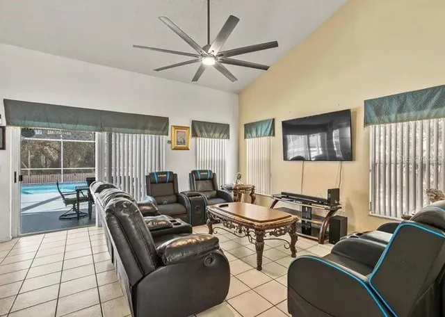 a living room with furniture a large window and a chandelier
