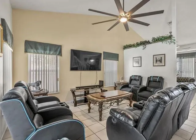 a living room with furniture ceiling fan and a window