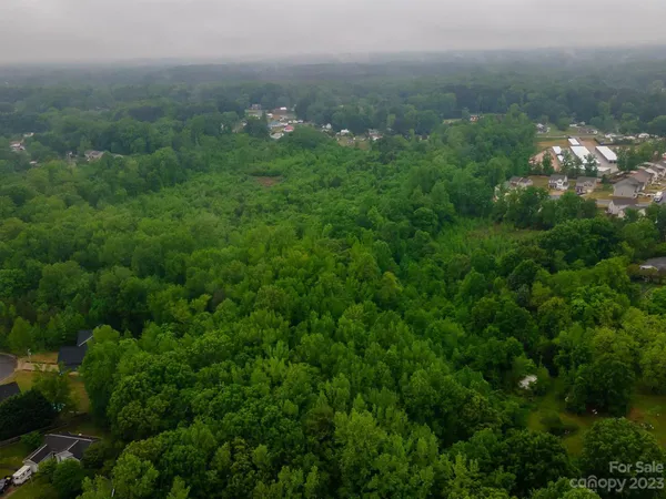 an aerial view of residential houses with outdoor space and trees
