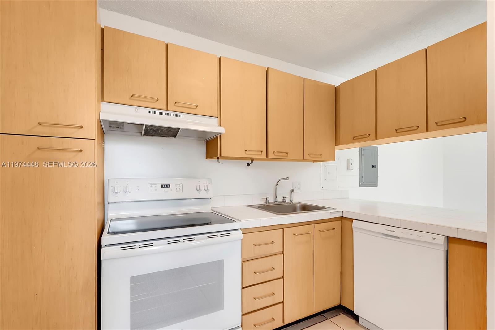 13787 Southwest 66th Street, Unit 254D Miami, FL 33183 - Photo 10 of 15 a kitchen with stainless steel appliances granite countertop a sink a stove and white cabinets with wooden floor