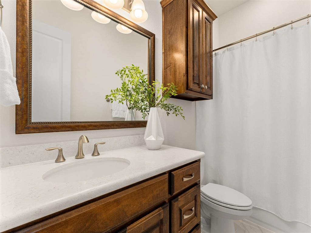 910 Marie Drive Allen, TX 75013 - Photo 23 of 38 a bathroom with a sink toilet and mirror