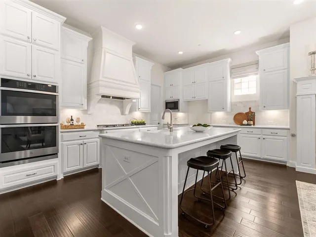 a kitchen with stainless steel appliances a stove a sink and a microwave