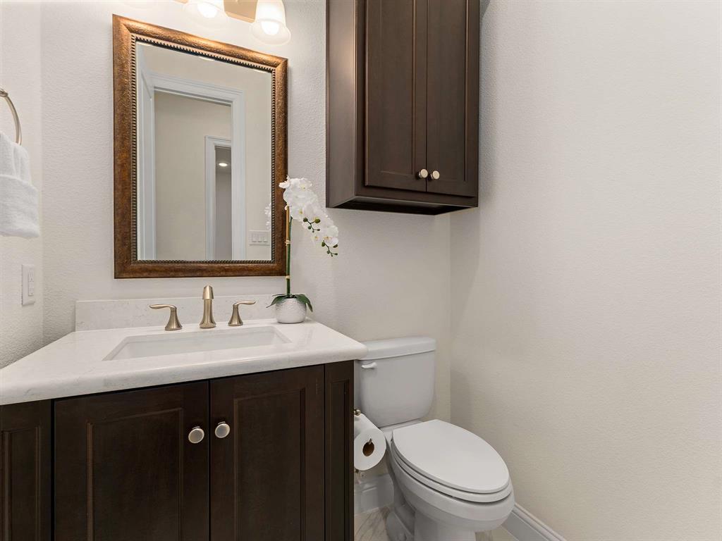 910 Marie Drive Allen, TX 75013 - Photo 32 of 38 a bathroom with a toilet sink and mirror