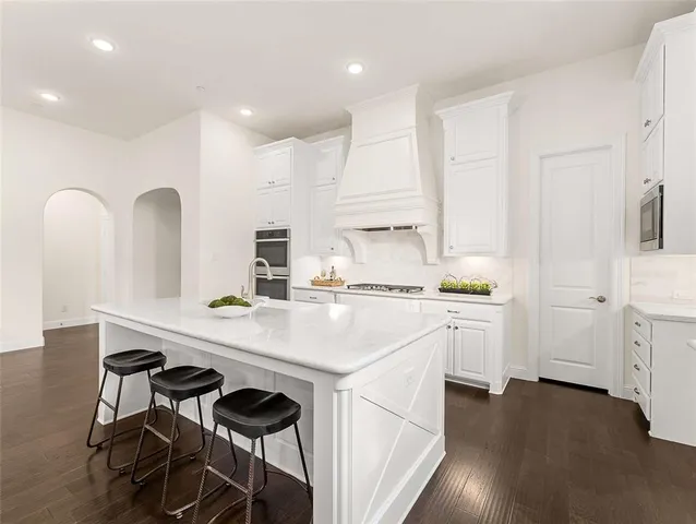 a kitchen with white cabinets and appliances