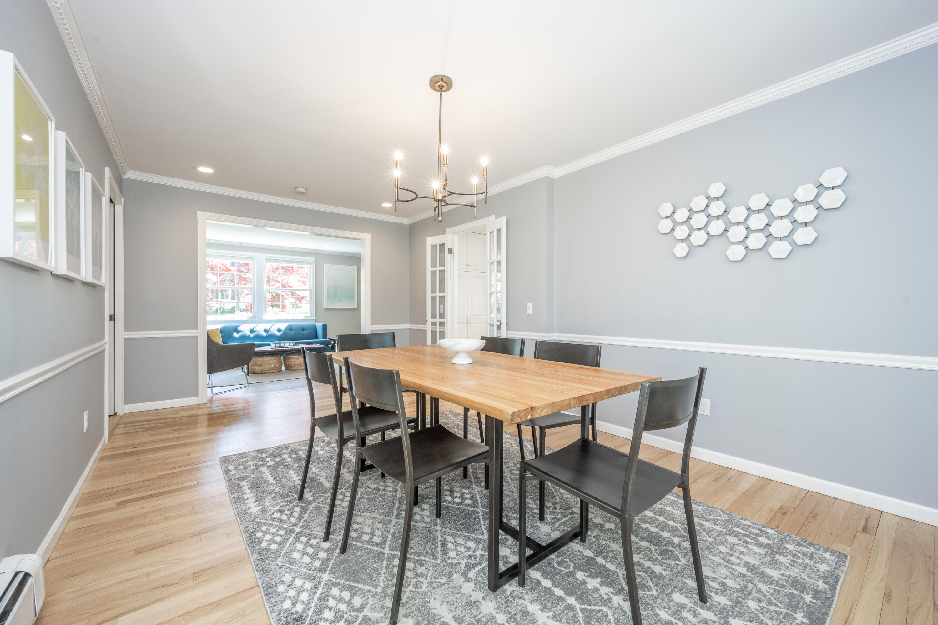 35 Miles Road Darien, CT 06820 - Photo 4 of 29 a dining room with wooden floor a chandelier a wooden table and chairs