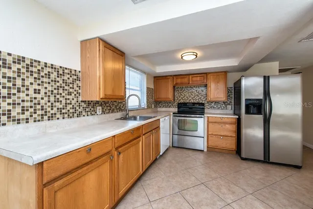 a kitchen with granite countertop a refrigerator and a sink