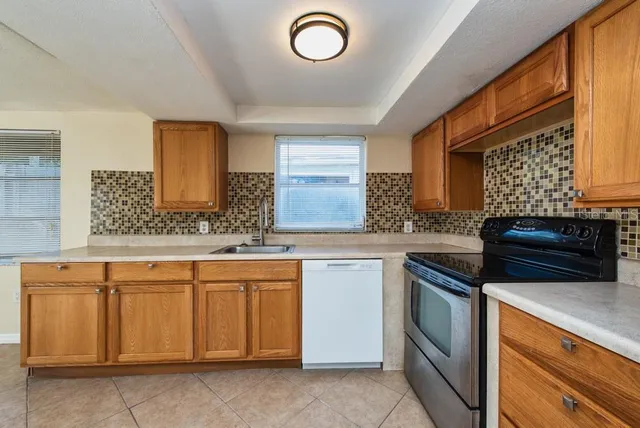 a kitchen with granite countertop a sink and a stove