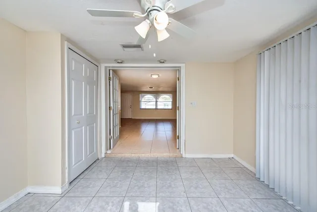 a view of a hallway with wooden floor and a chandelier
