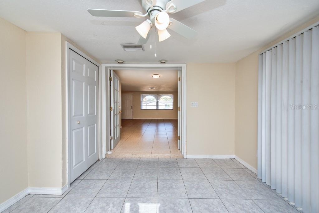 5117 School Road New Port Richey, FL 34653 - Photo 7 of 24 a view of a hallway with wooden floor and a chandelier