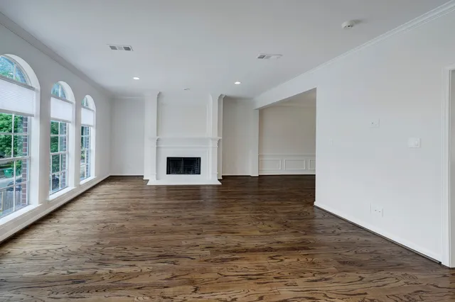 a backyard of a house with plants and large tree