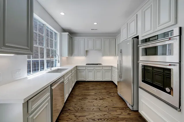 a kitchen with a sink cabinets and wooden floor
