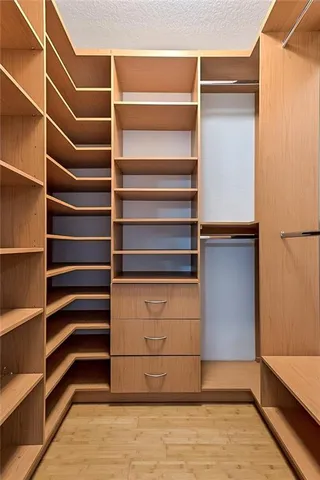 a view of walk in closet with empty racks