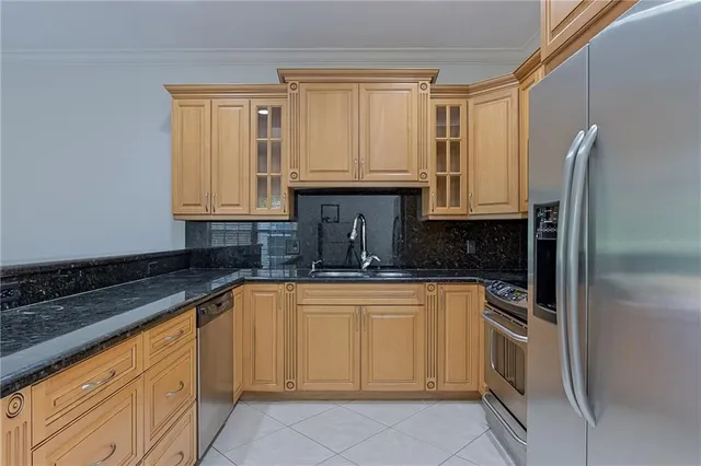 a kitchen with granite countertop a sink stainless steel appliances and cabinets
