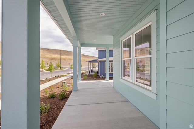 7189 South Sage Road, Unit 214 West Jordan, UT 84081 - Photo 3 of 29 Covered concrete front porch featuring painted columns and a paneled ceiling