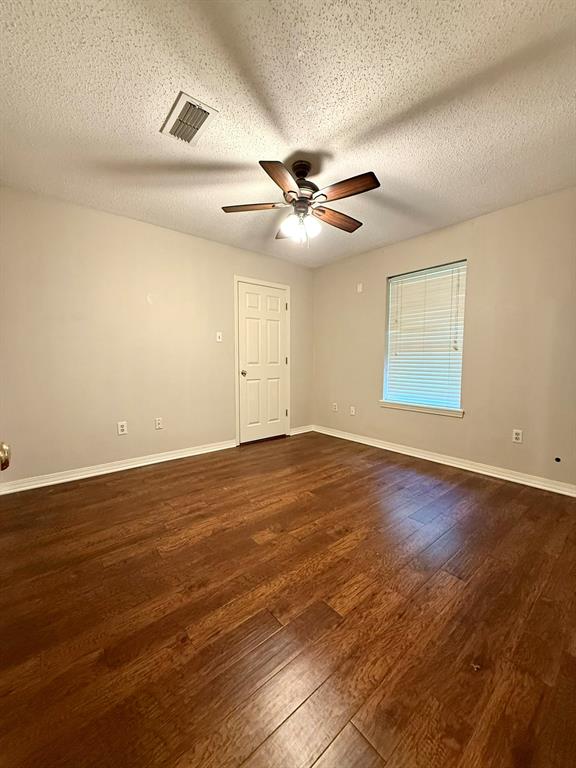 11535 Timber Ridge Drive Keithville, LA 71047 - Photo 10 of 39 an empty room with wooden floor ceiling fan and windows