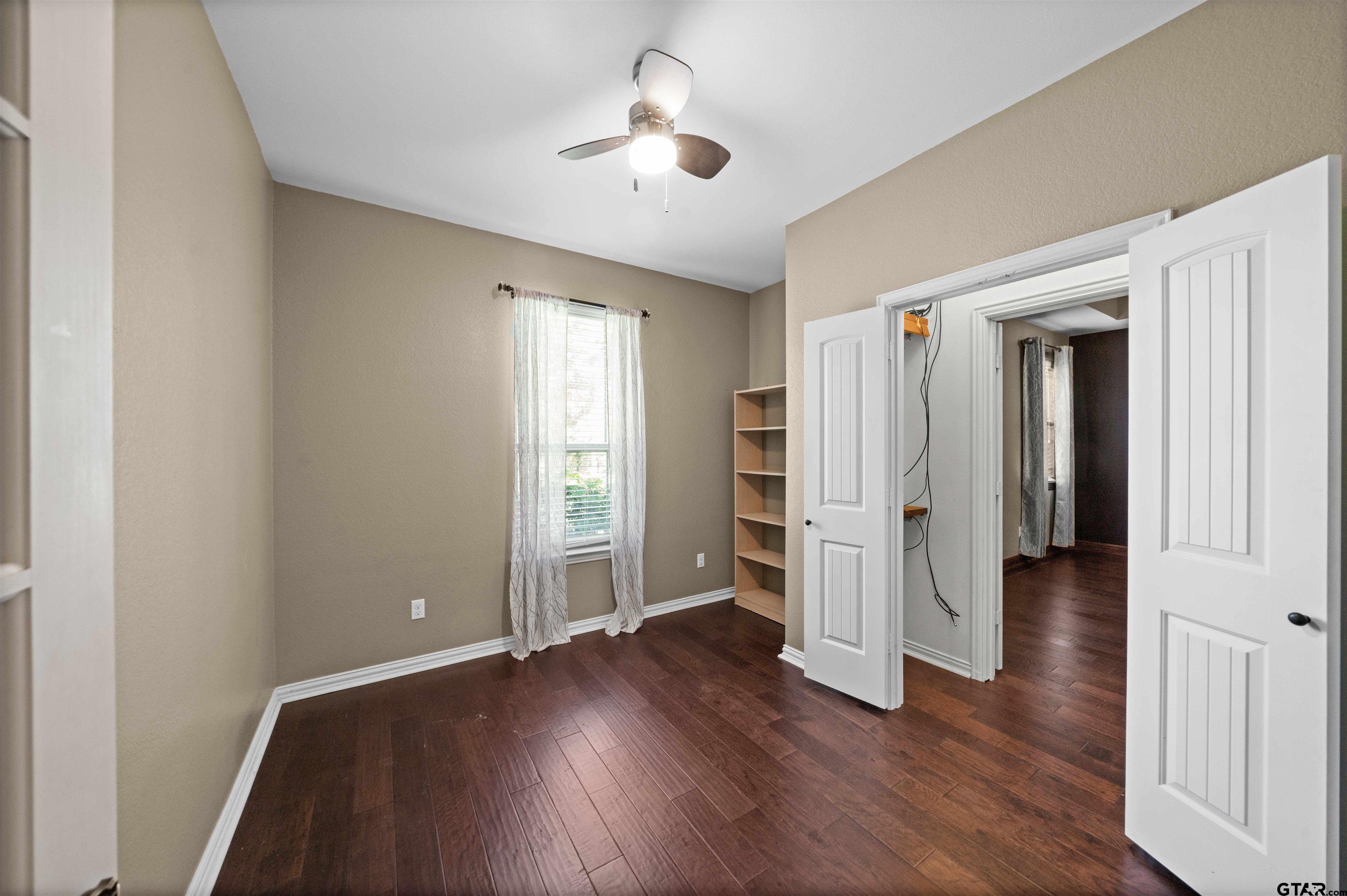 17153 County Road 1108 Flint, TX 75762 - Photo 20 of 45 an empty room with wooden floor and ceiling fan