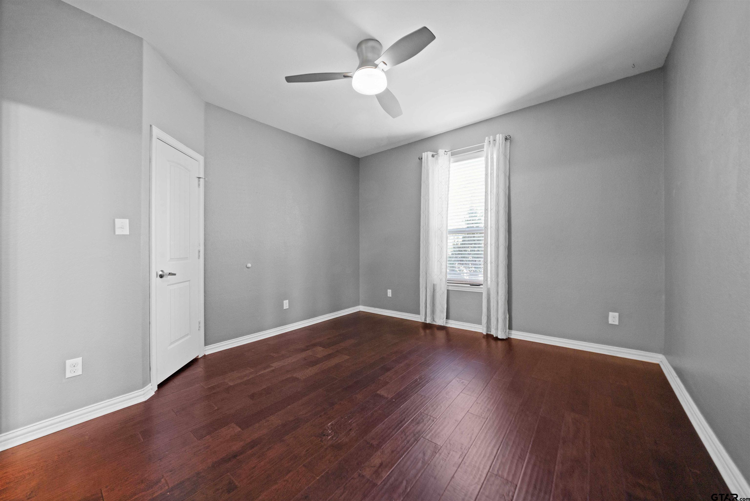 17153 County Road 1108 Flint, TX 75762 - Photo 33 of 45 an empty room with wooden floor and a ceiling fan