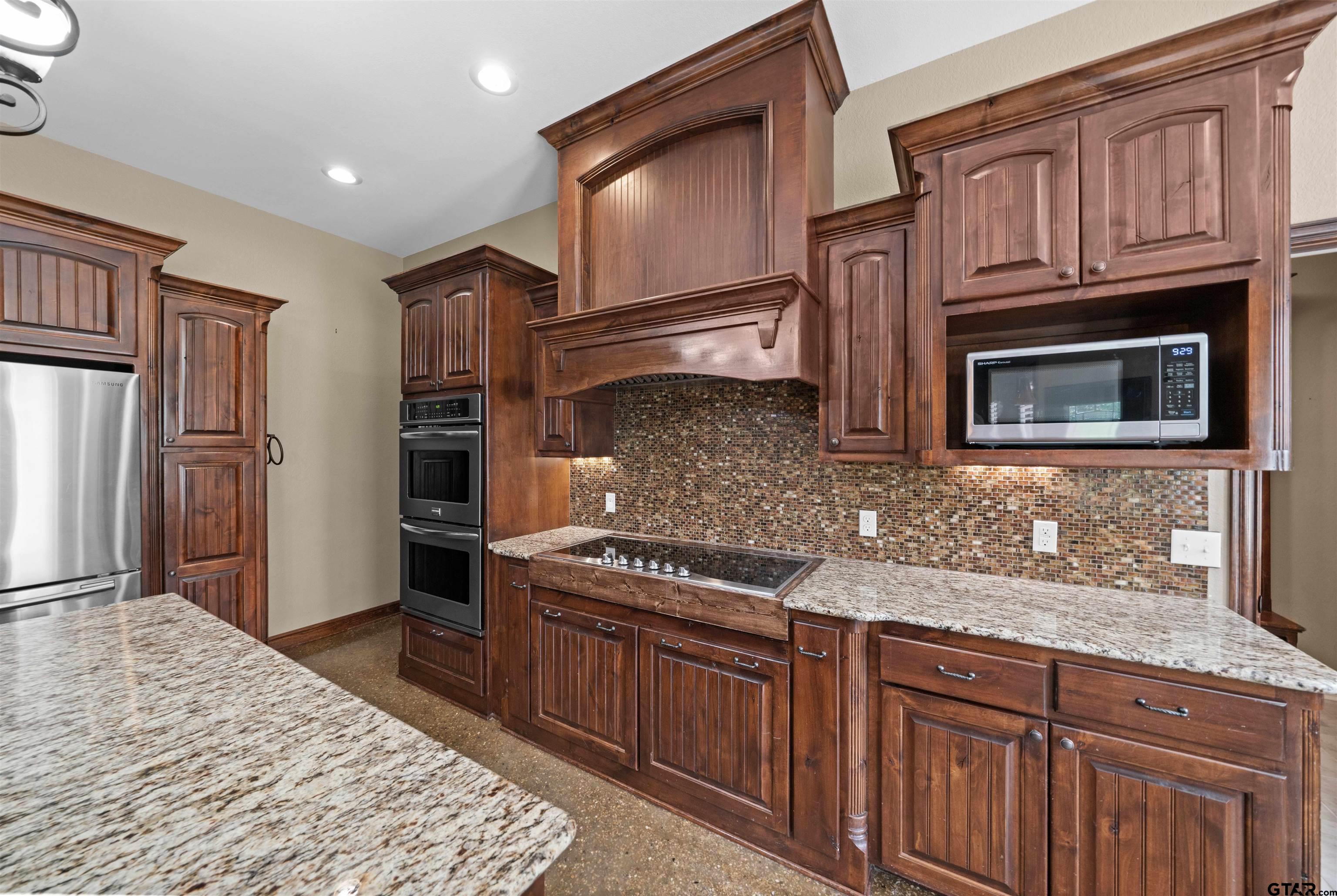 17153 County Road 1108 Flint, TX 75762 - Photo 8 of 45 a kitchen with stainless steel appliances granite countertop a stove microwave and refrigerator