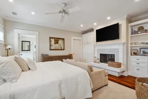a bedroom with a bed a flat screen tv and a fireplace