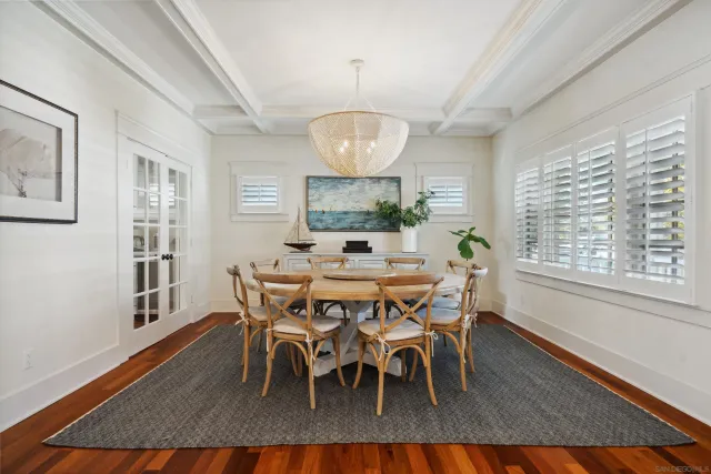 a dining room with wooden floor a glass table and chairs