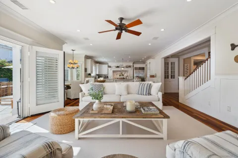 a living room with furniture kitchen view and a window