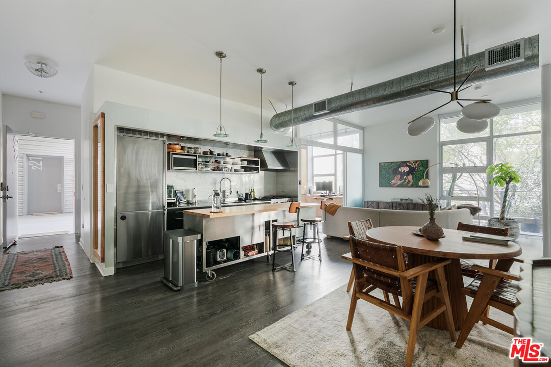 a room with stainless steel appliances kitchen island granite countertop furniture and wooden floor