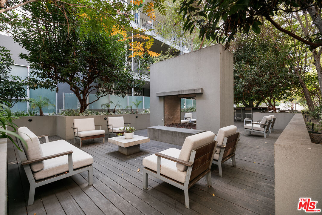 4080 Glencoe Avenue, Unit 219 Marina del Rey, CA 90292 - Photo 28 of 31 a view of a patio with couches and a table and chairs with wooden floor and fence