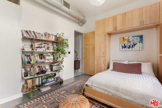 a bedroom with a bed and a book shelf