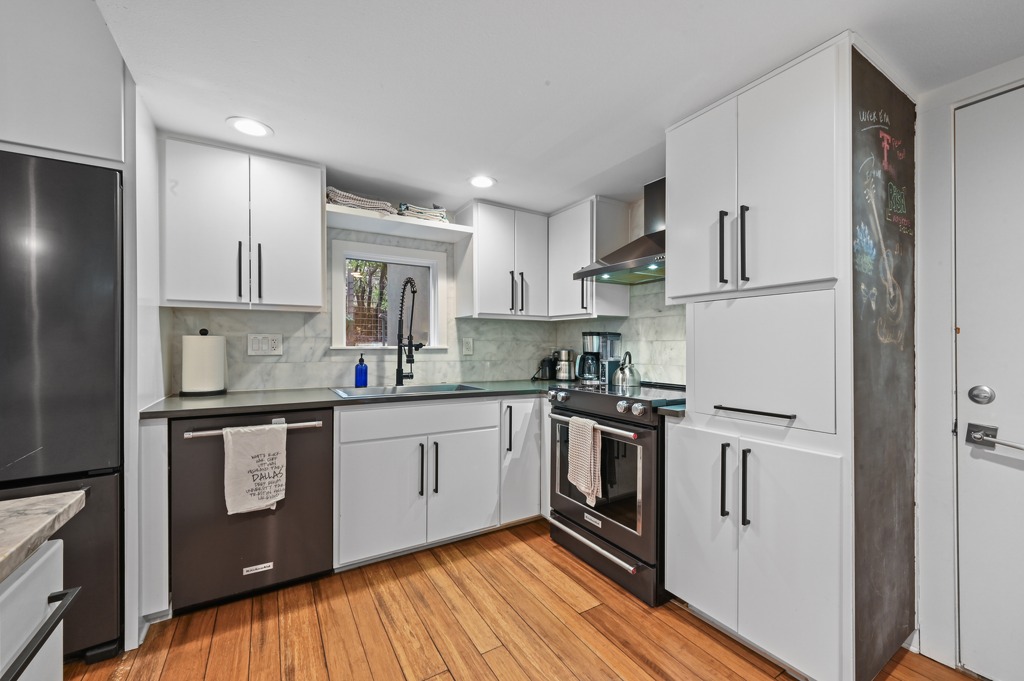 2101 Airole Way, Unit B Austin, TX 78704 - Photo 15 of 28 a kitchen with stainless steel appliances granite countertop a stove a refrigerator and white cabinets with wooden floors