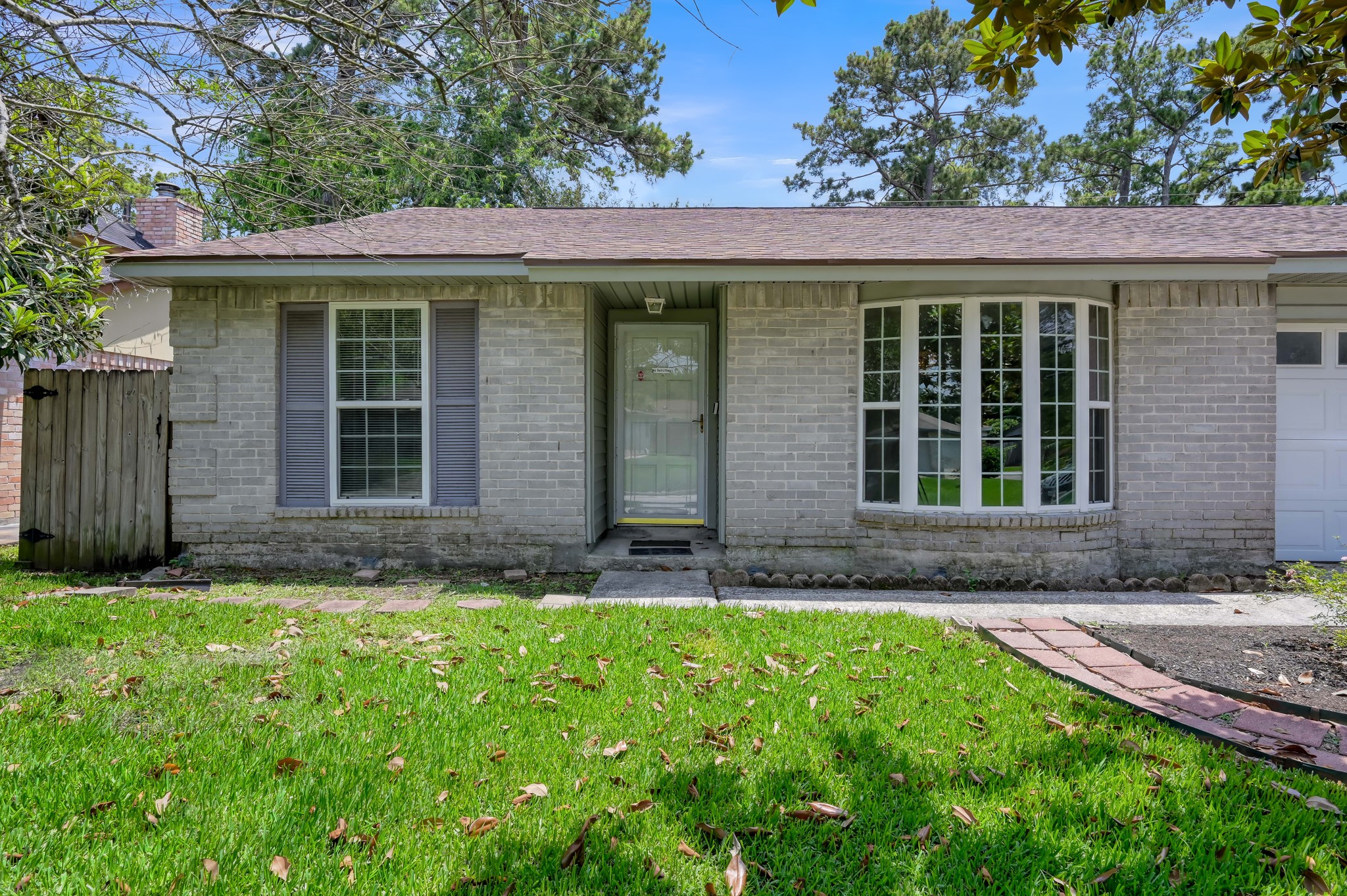 4314 Enchantedgate Drive Spring, TX 77373 - Photo 3 of 47 Charming single-story home with light-colored brick exterior, featuring a welcoming front door and large bay window. The well-maintained lawn and mature trees create a pleasant curb appeal.