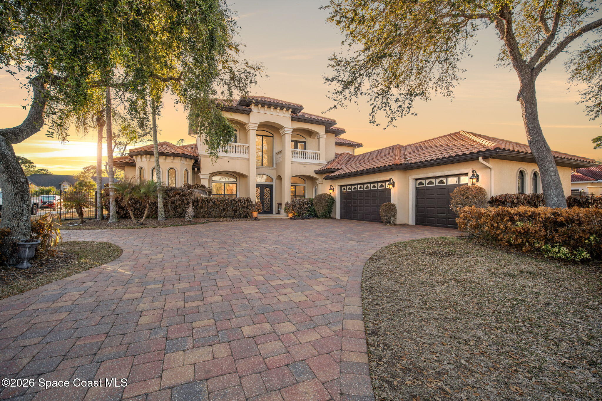 a front view of a house with a yard and trees