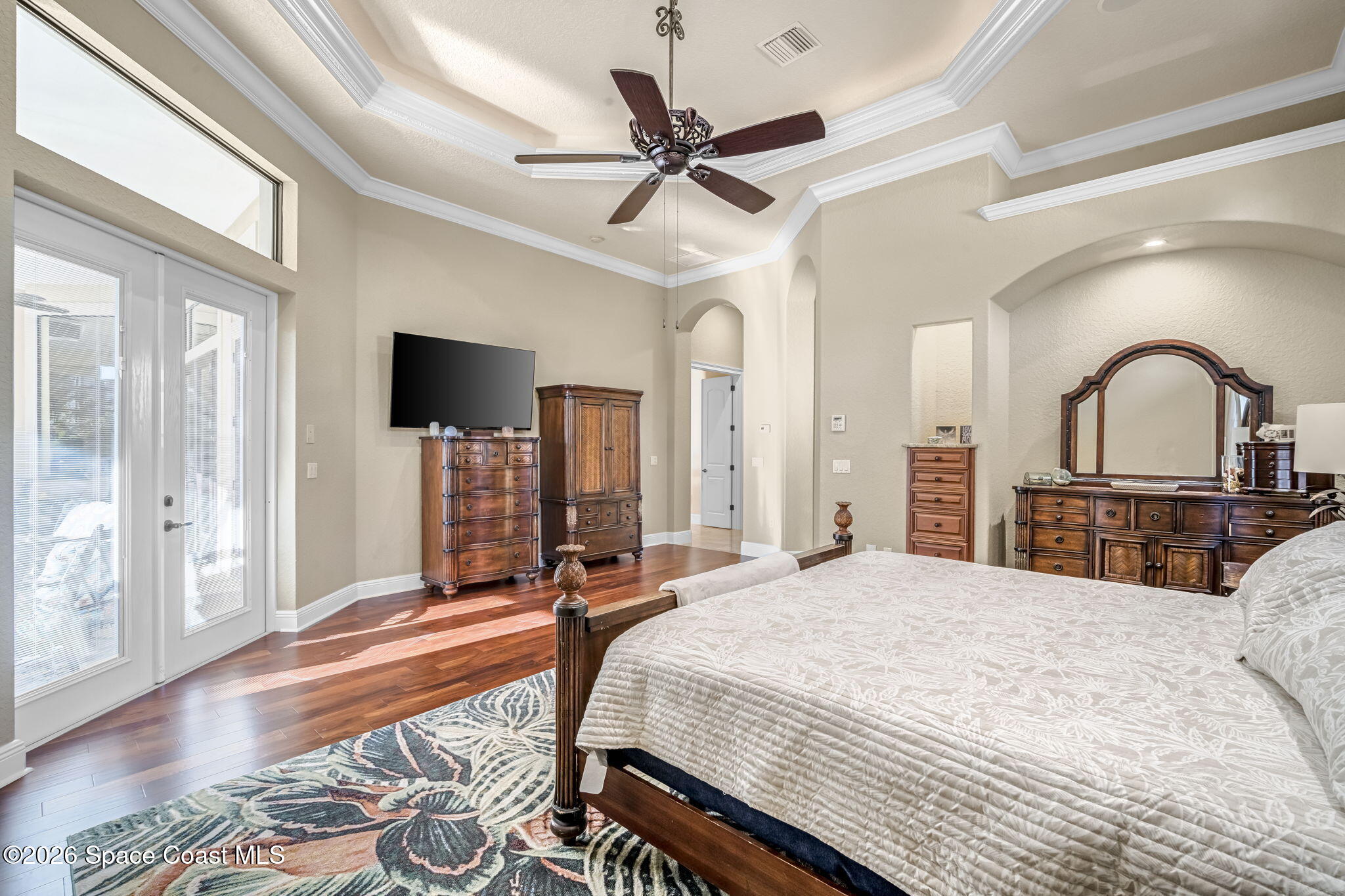 5454 Riveredge Drive Titusville, FL 32780 - Photo 28 of 70 a bedroom with a large bed and a chandelier
