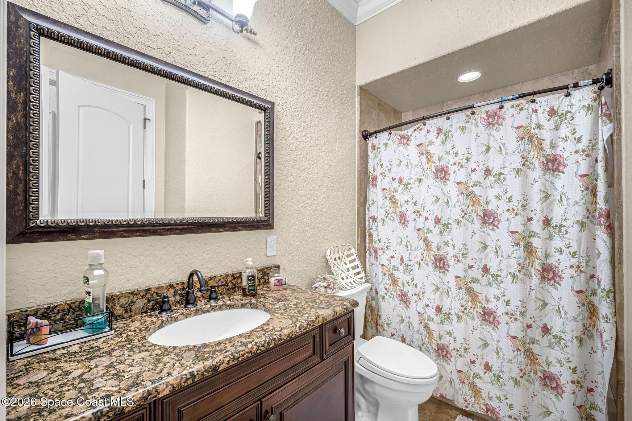 5454 Riveredge Drive Titusville, FL 32780 - Photo 38 of 70 a bathroom with a granite countertop sink a toilet and a mirror
