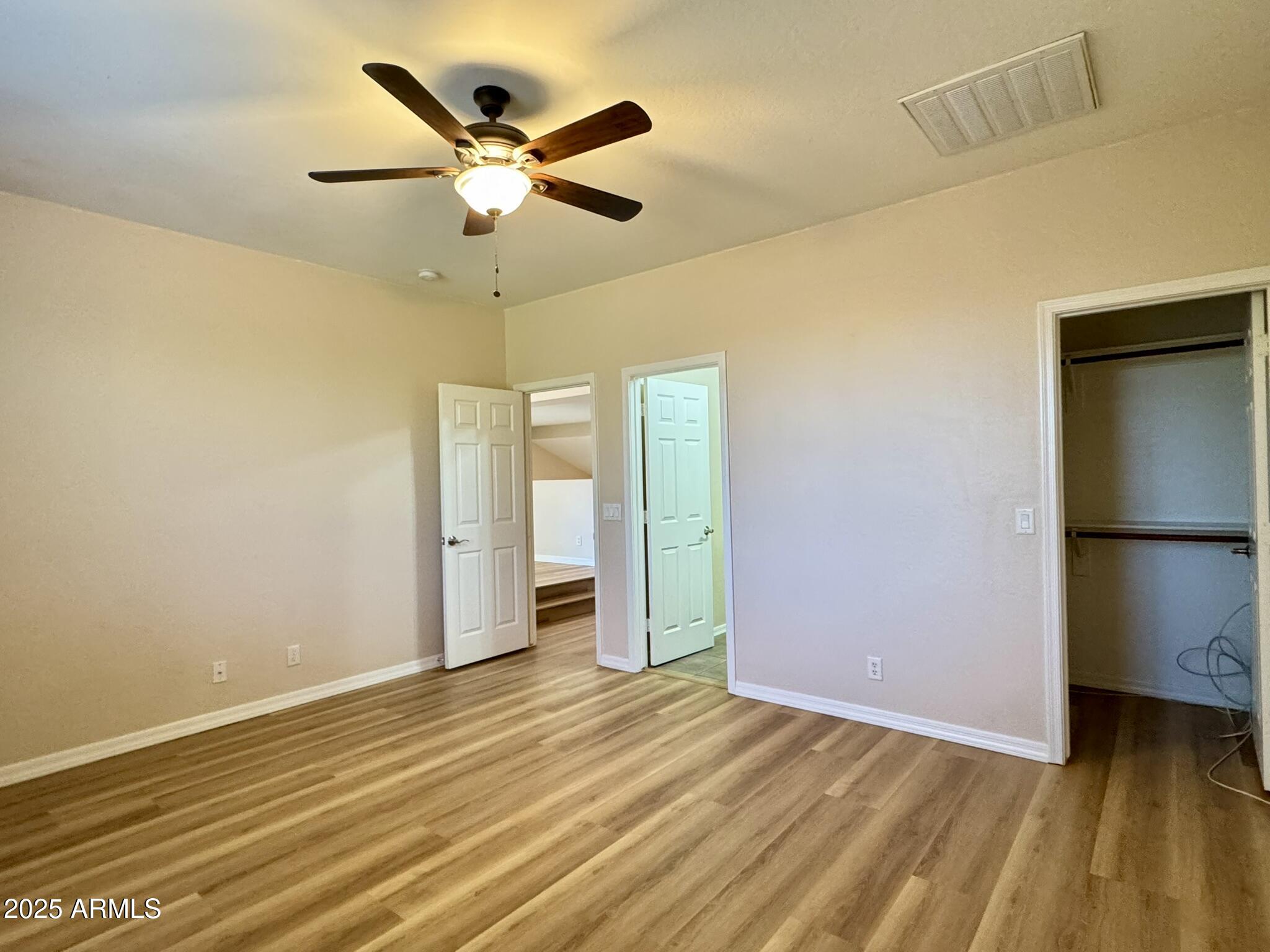 2671 South Dragoon Drive Chandler, AZ 85286 - Photo 20 of 41 an empty room with a ceiling fan and wooden floor