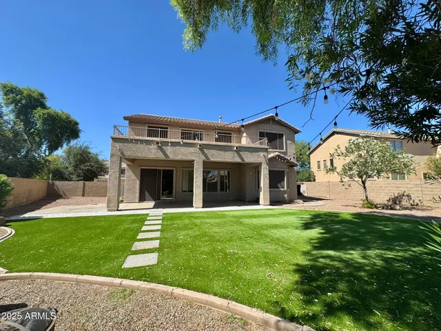 a view of a house with a yard and potted plants