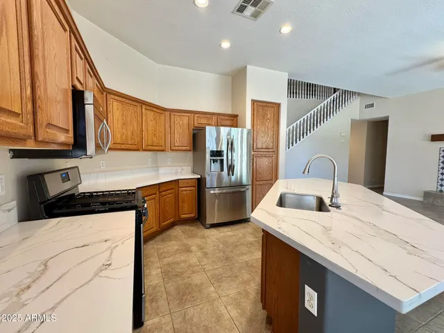 a kitchen with granite countertop a sink stove and refrigerator